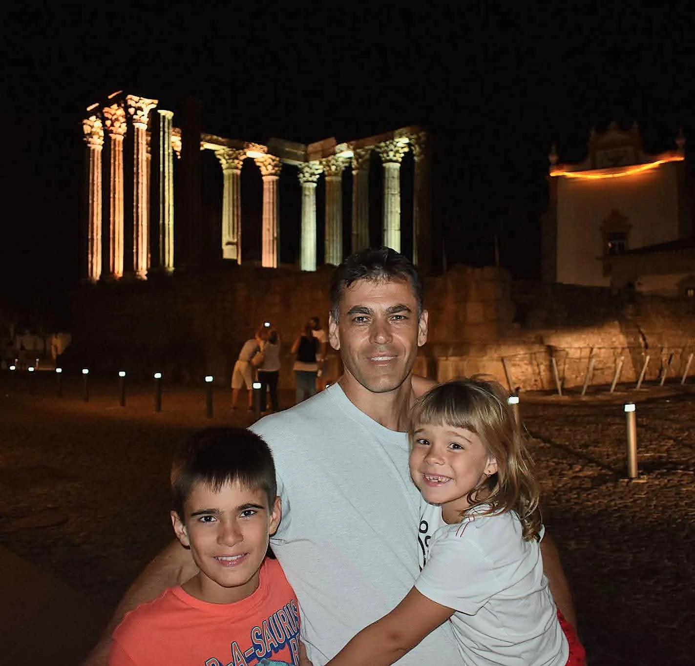 Northern Roots Travel family visiting a historic Portuguese heritage site at night, representing the connection between generations and Portuguese roots.