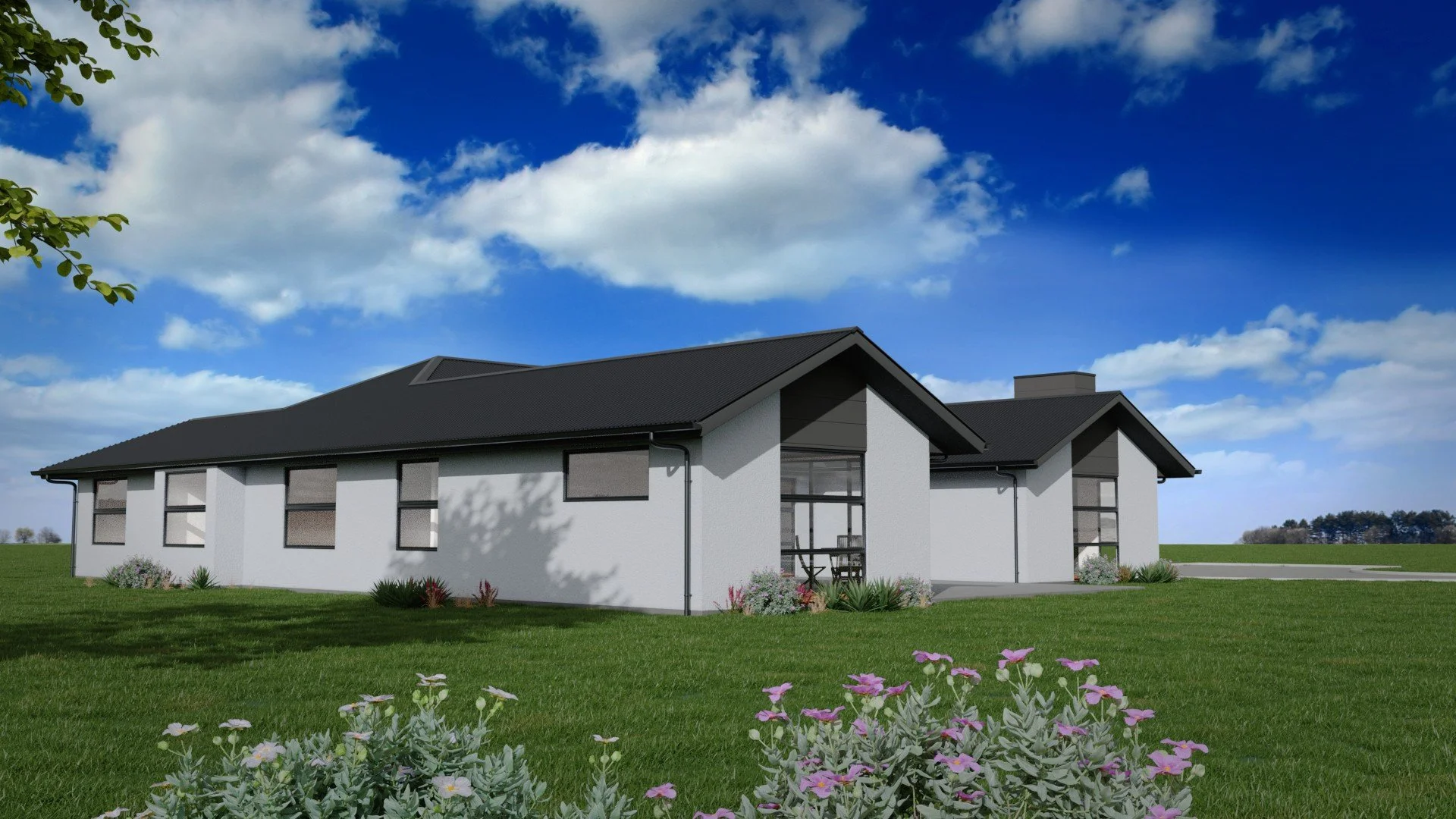 Modern white house with dark roof and multiple windows, landscaped yard with flowers and green grass, clear blue sky with clouds in the background.