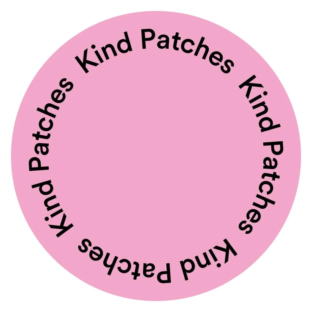 Pink circular sticker with black text that reads: "Kind Patches"
