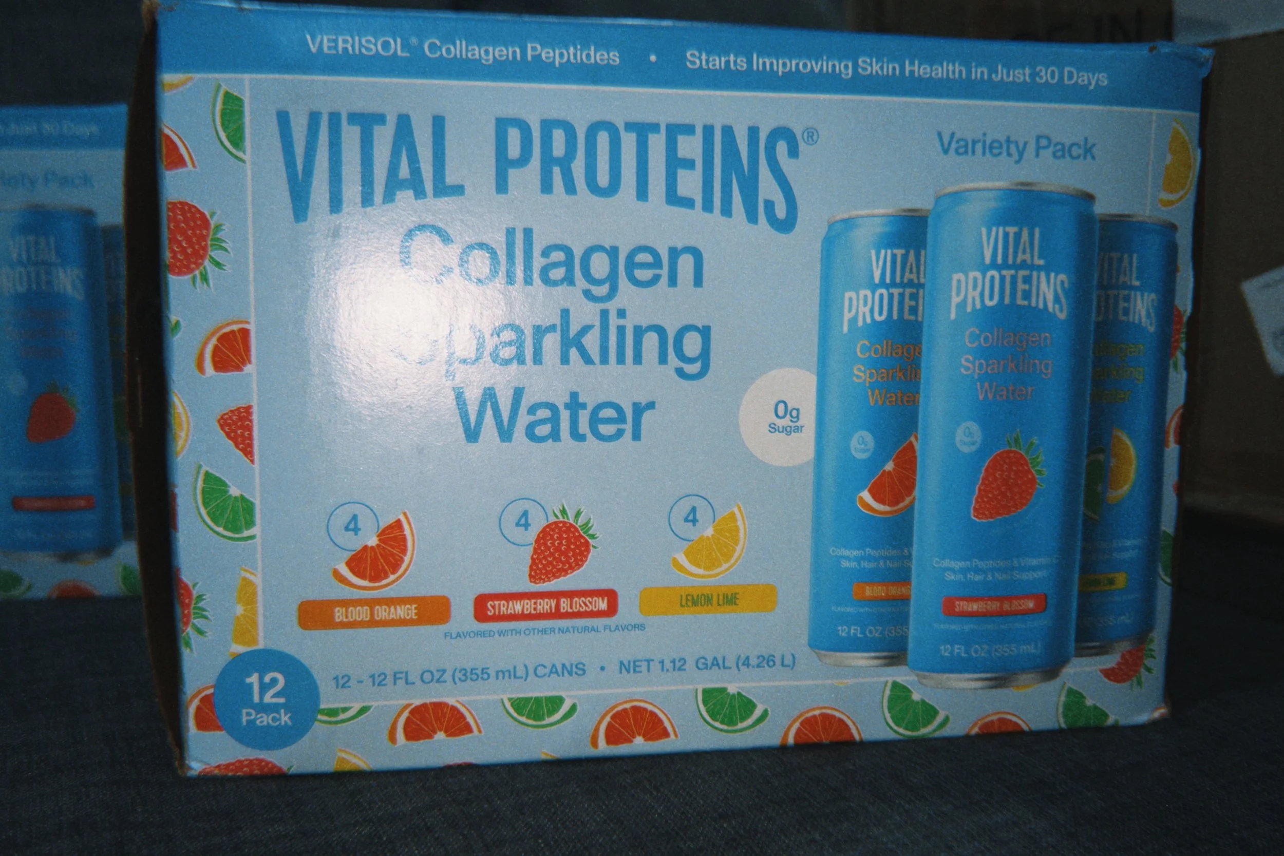 A box of Vital Proteins Collagen Sparkling Water Variety Pack with different flavors, including blood orange, strawberry blossom, lemon lime, and strawberry hibiscus. The package contains 12 cans, each 12 fluid ounces.