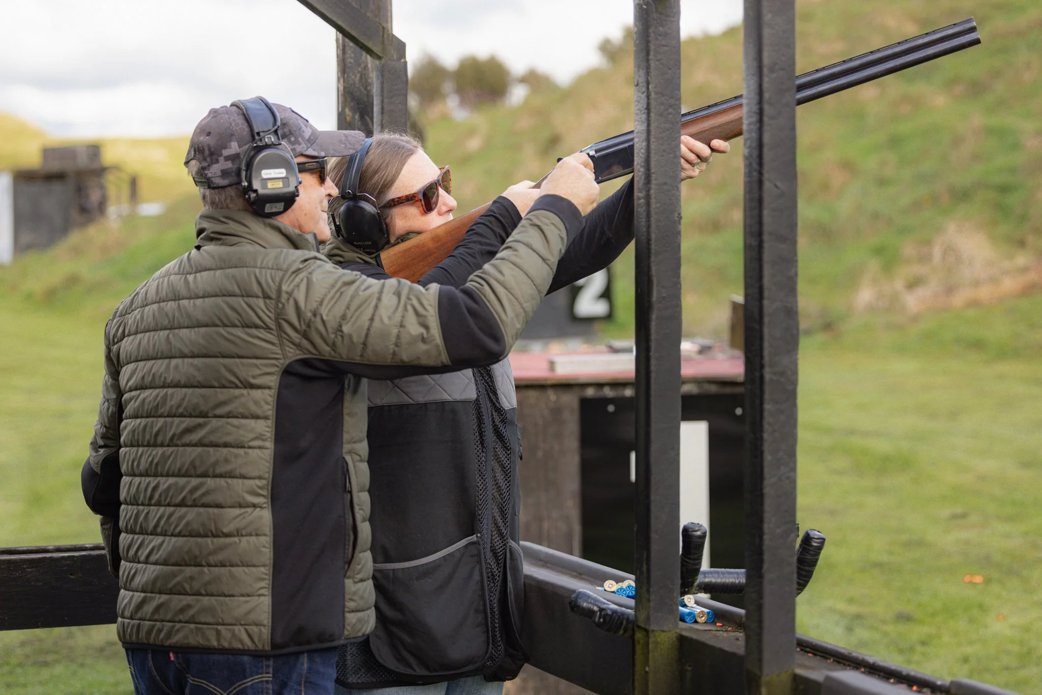 Clay bird shooting instructor helping corporate client aim for target for clay bird shooting at the Loaded NZ range