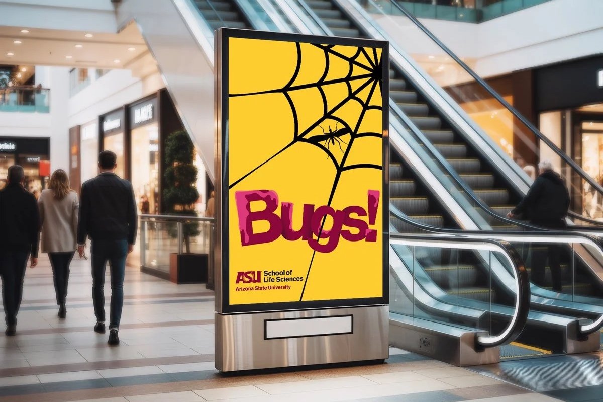 View of a poster display in a shopping mall with people walking around.
