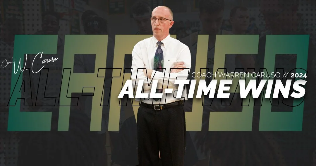 A man in a white shirt and colorful tie standing with arms crossed in front of a backdrop that says "ALL-TIME WINS" and "COACH WARREN CARUSO 2024" with the name "W. Caruso" written in script.
