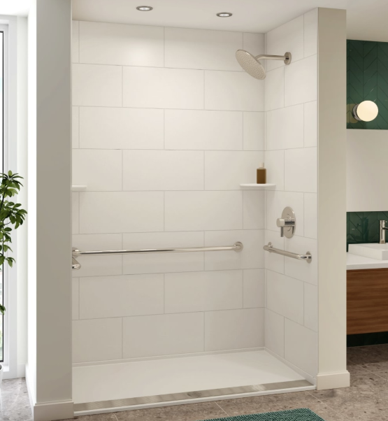Accessible walk-in shower with a showerhead, a horizontal grab bar, a wall-mounted control, a shelf with a soap bottle, and a partial view of a bathroom vanity with a sink and mirror.
