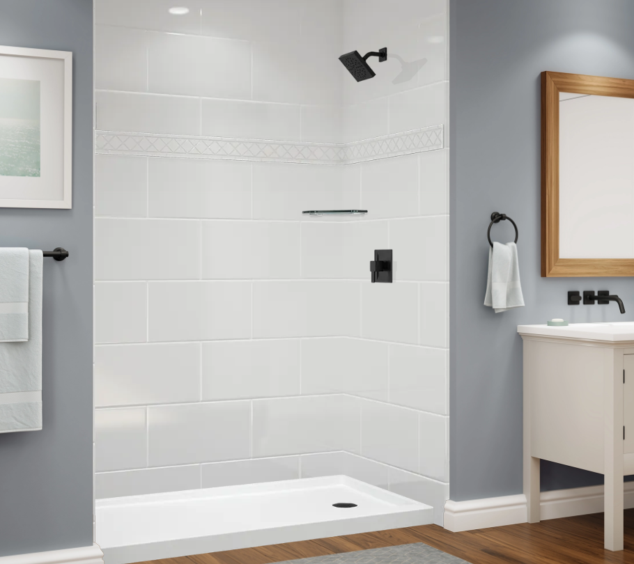 A modern bathroom shower with gray tiled wall, black shower head, and a framed abstract art piece on the wall next to a window.
