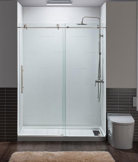 Modern glass-enclosed shower with a sliding door in a contemporary bathroom, with a toilet next to it on the right.