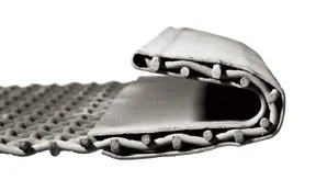 Close-up of an industrial conveyor belt with metal slats and rubber surface.