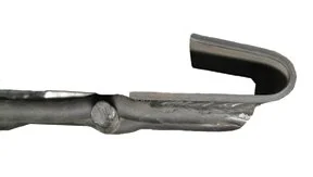 Close-up of a metal tool or instrument with a curved hook at the end.