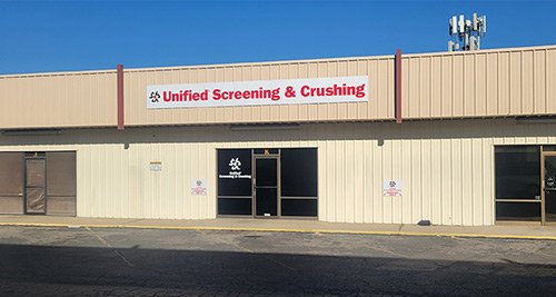 Exterior of a building with a sign that reads 'Unified Screening & Crushing'