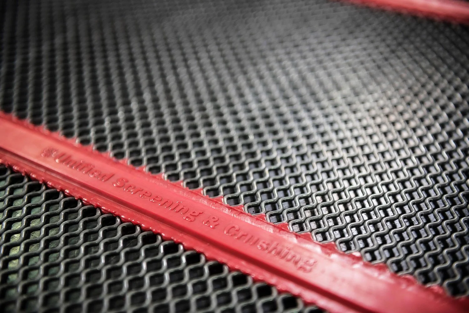 Close-up of a black metal grill with a red rubber strip along the edge that reads 'Sanding & Cushing & Remolding'.