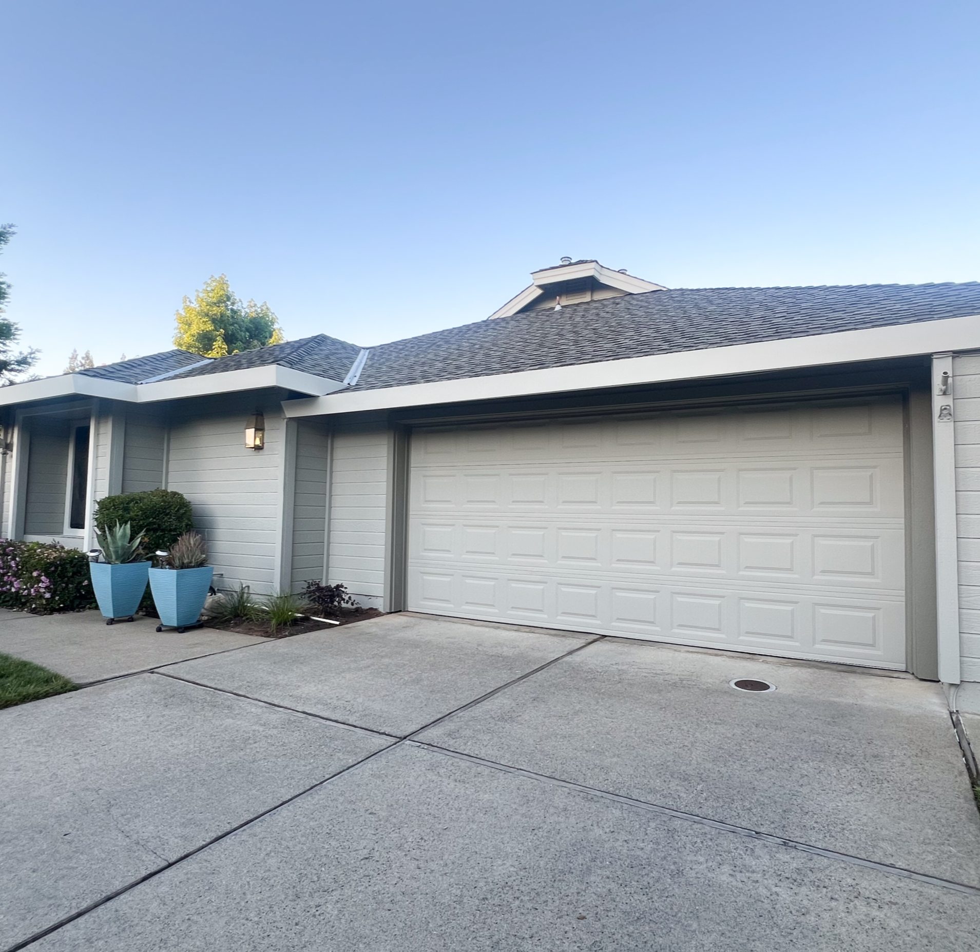 Finished exterior house painting project featuring a modern gray paint color on a residential home.