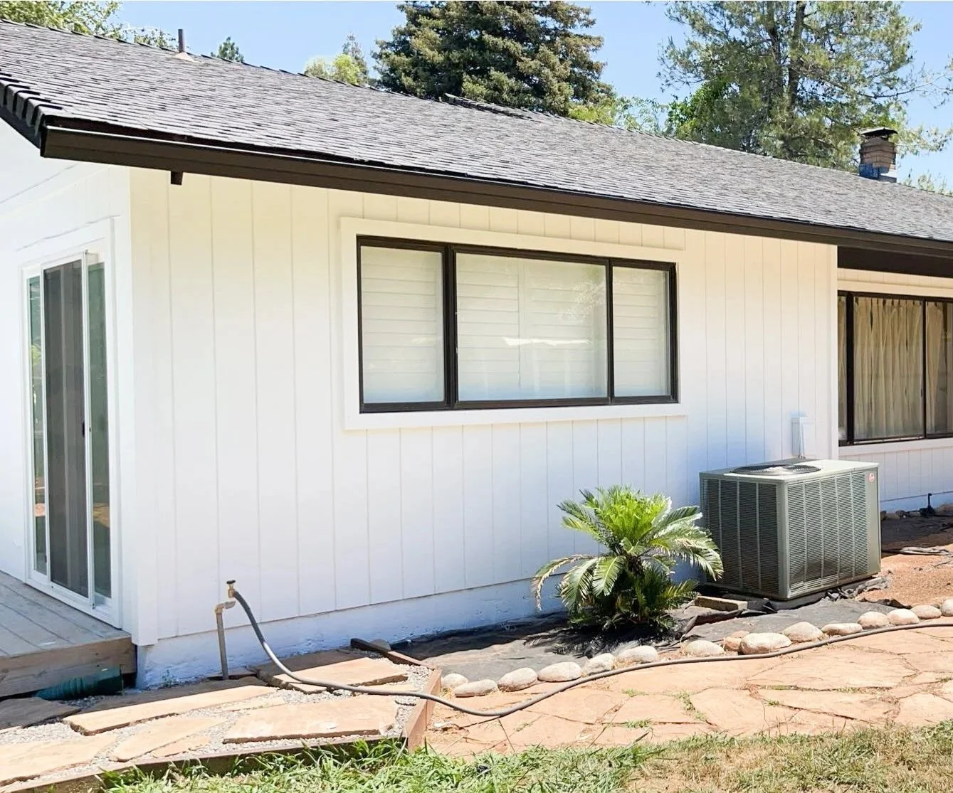 Completed exterior house painting featuring a clean white finish on a residential home.