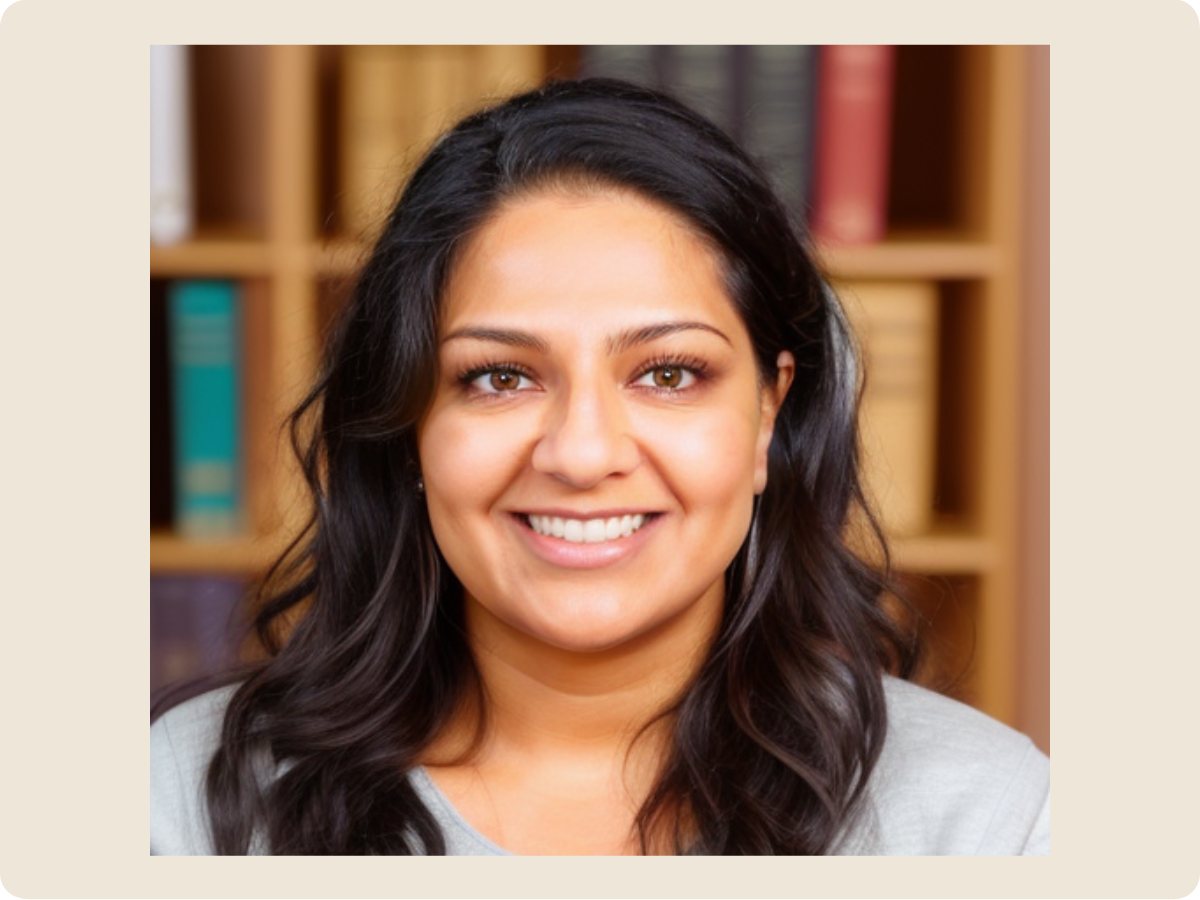 A woman with long dark hair smiling in front of a bookshelf with colored books.