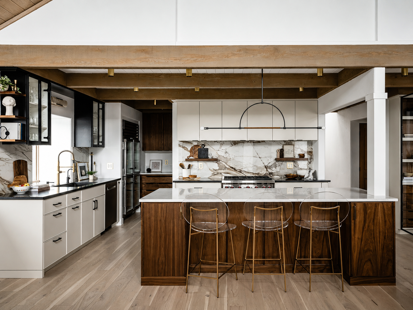 Modern kitchen with white cabinets, wooden accents, marble backsplash, and a large island with marble countertop and transparent chairs.