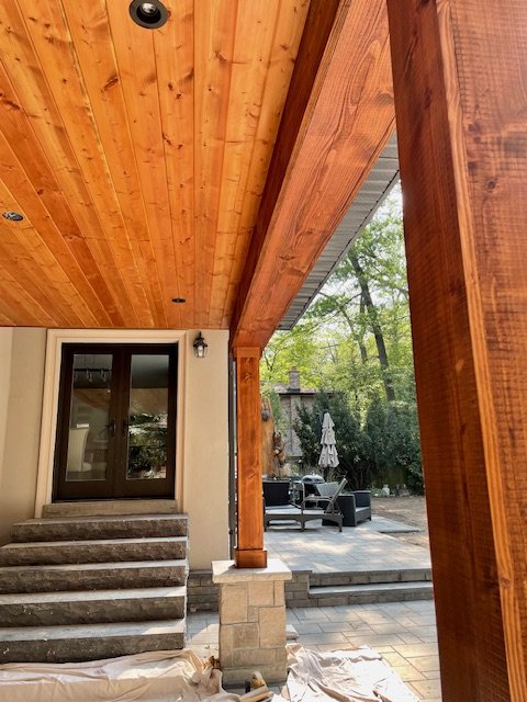 cedar covered back deck with columns and stone work