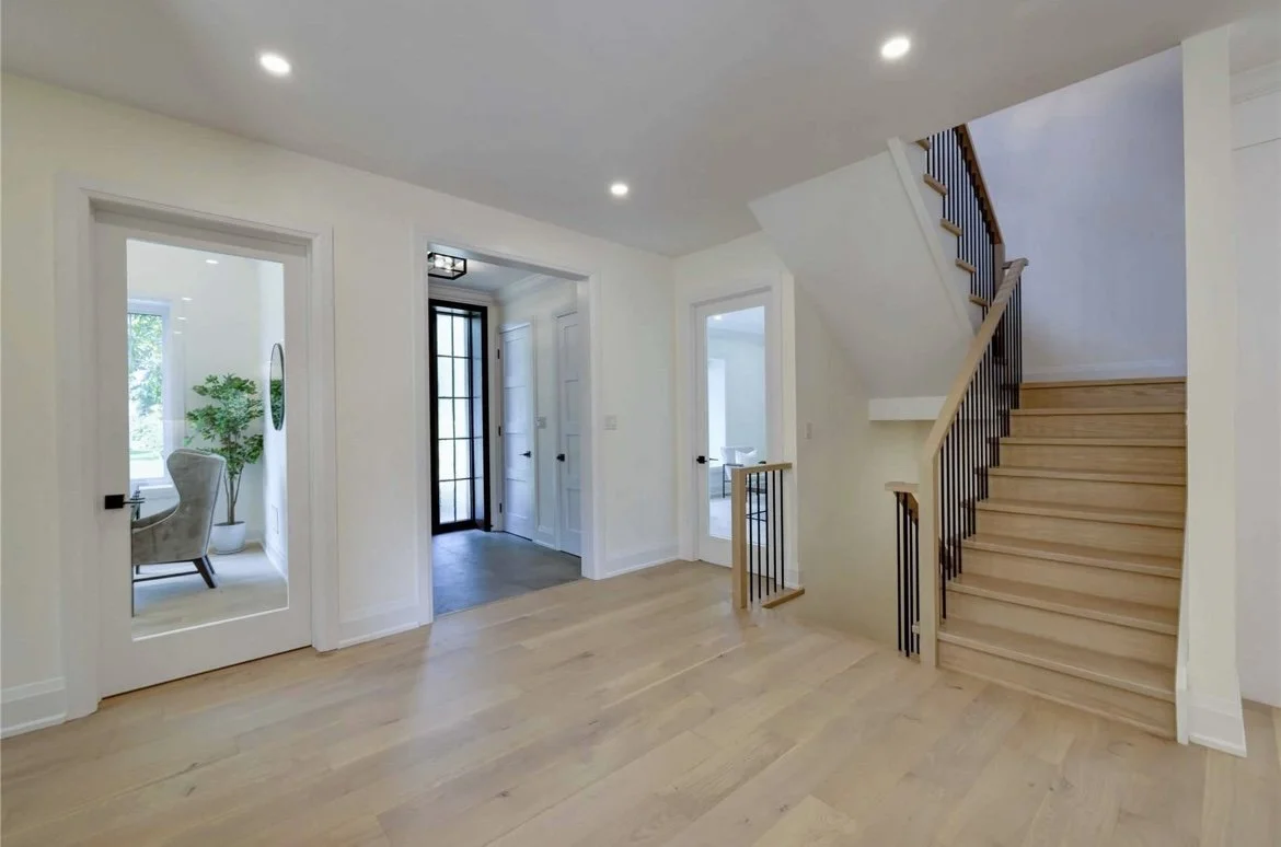 main floor renovation with modern staircase, white oak flooring, glass doors and trim