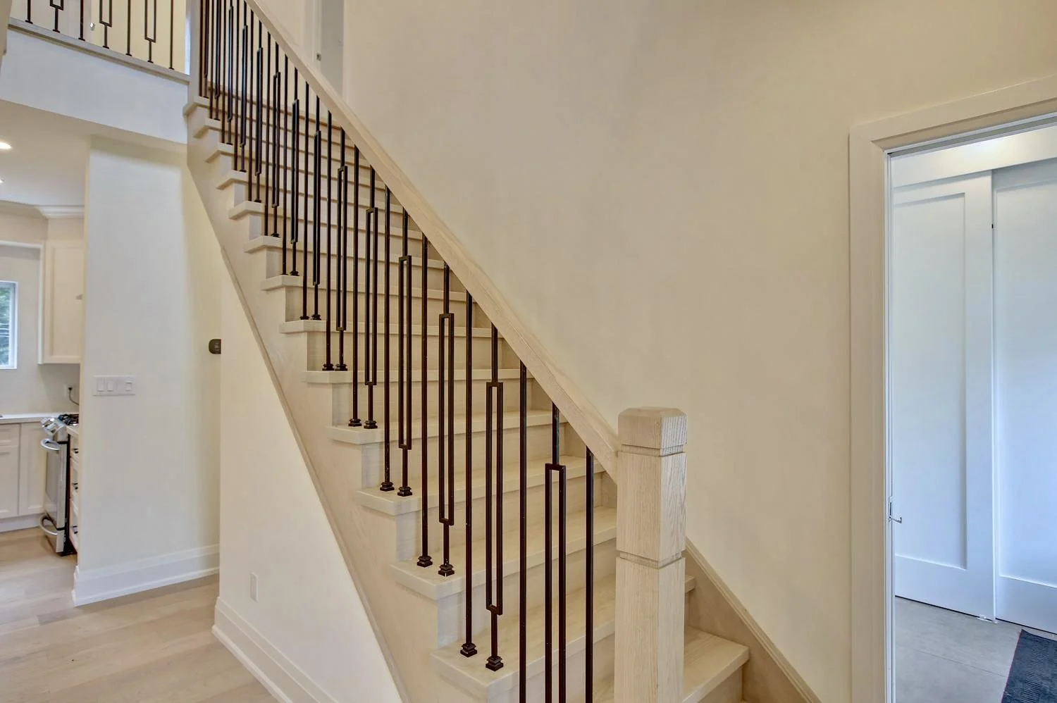 Modern stairs with wooden handrails and black metal spindles