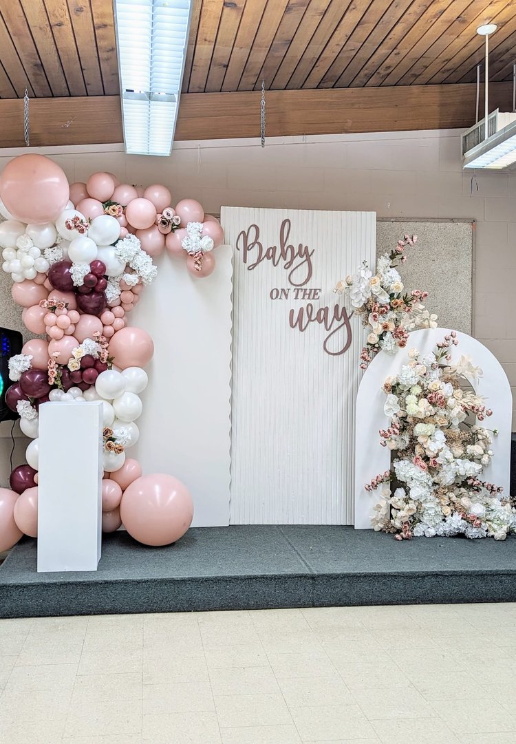 Three-panel backdrop with ripple wall, open arch, florals and blush balloon arch