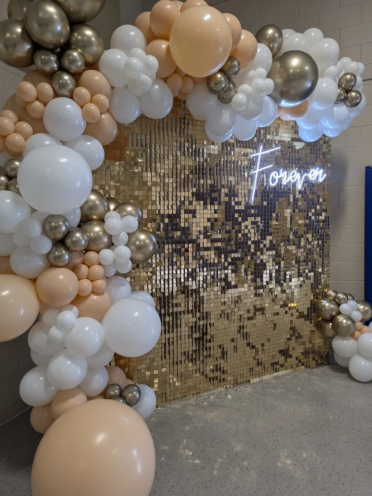 Gold sequin shimmer wall with peach, white and gold balloon arch