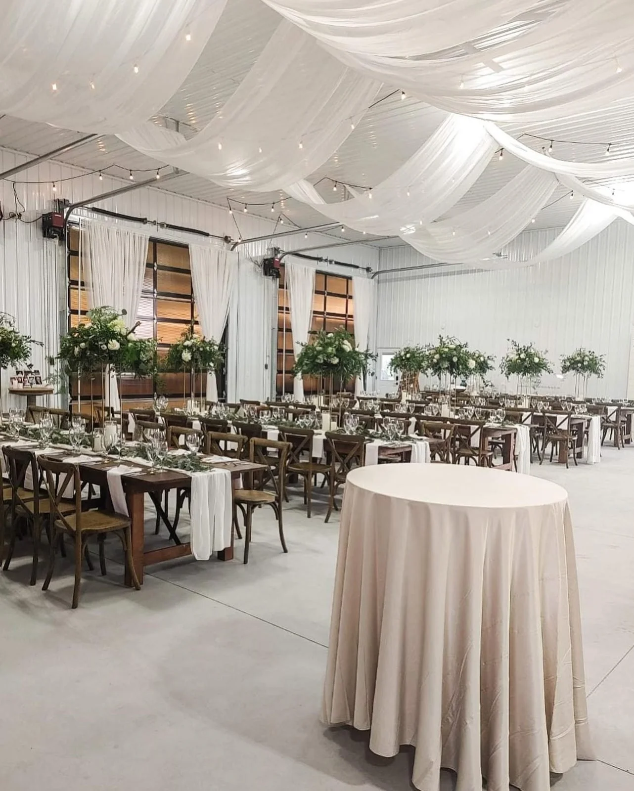 Barn wedding reception with draped ceiling swags and string lights by Real Event Designs