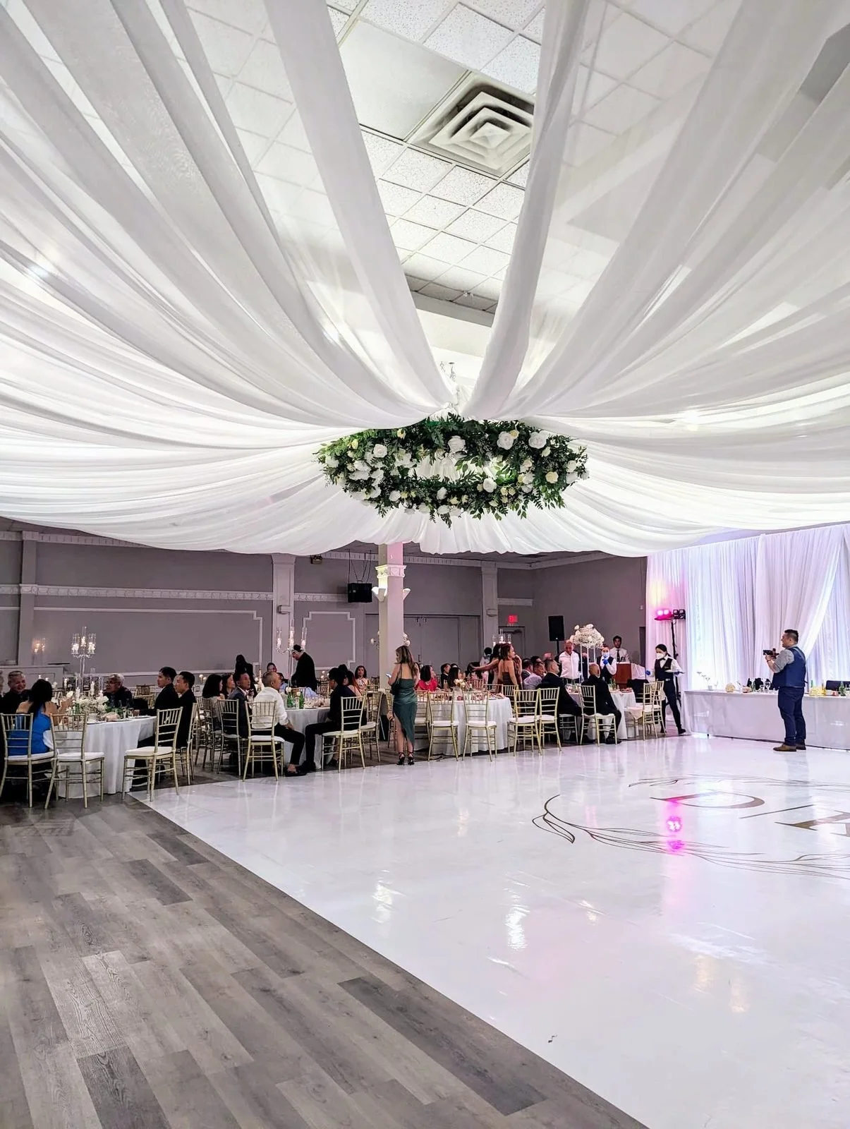 Ballroom ceiling drapery canopy radiating from a floral hoop, designed by Real Event Designs