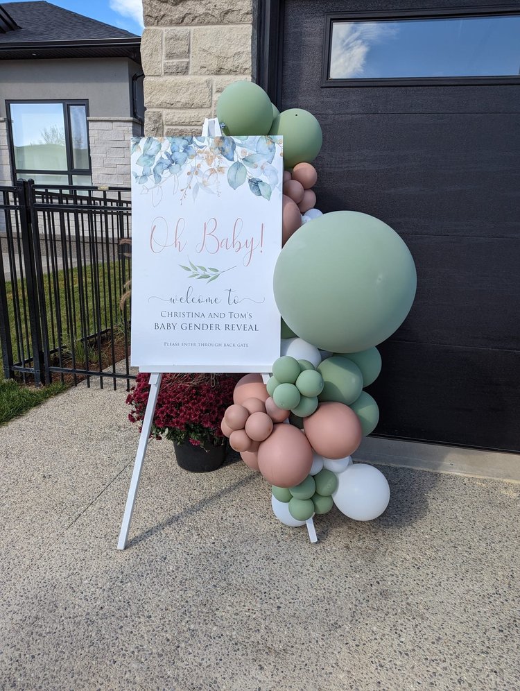 Custom welcome sign on an easel with sage and blush balloon cluster