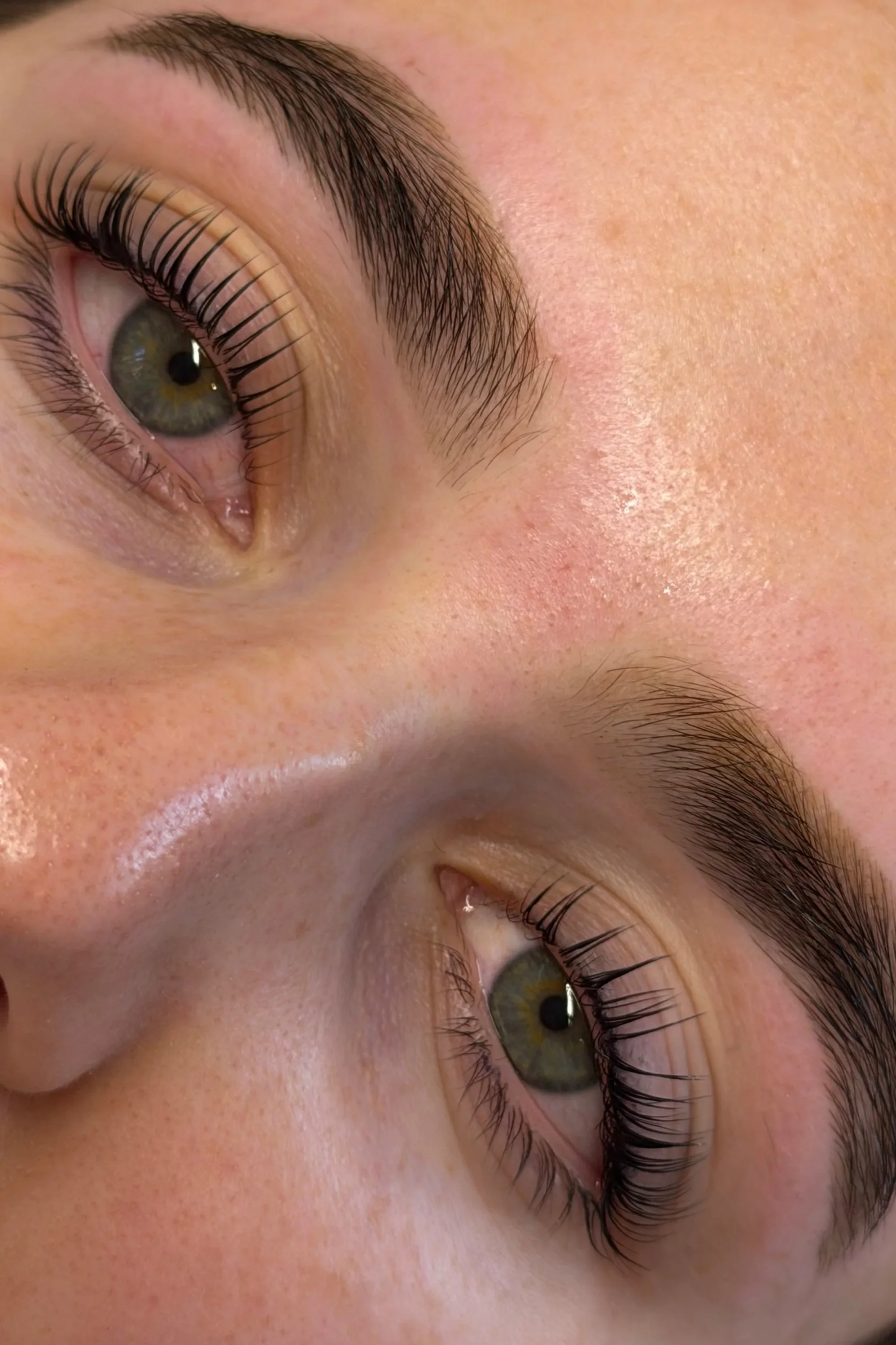 Close-up of a person's eye, showing the eye's iris, eyelashes, and eyebrow with clear skin.