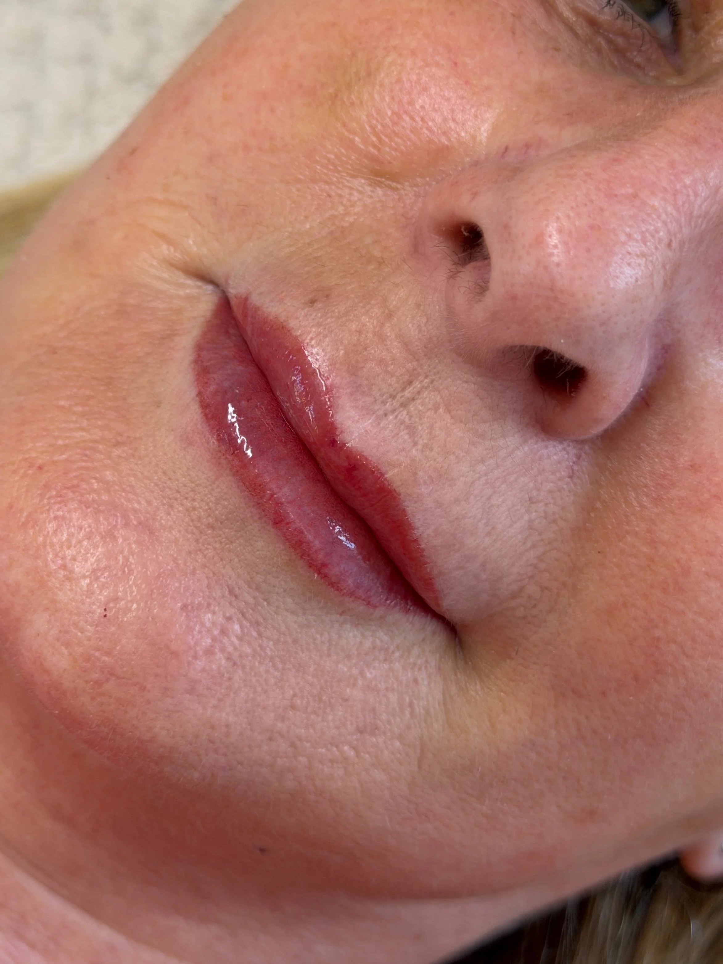 Close-up of a person's nose and lips, with a slightly open mouth and visible skin texture.
