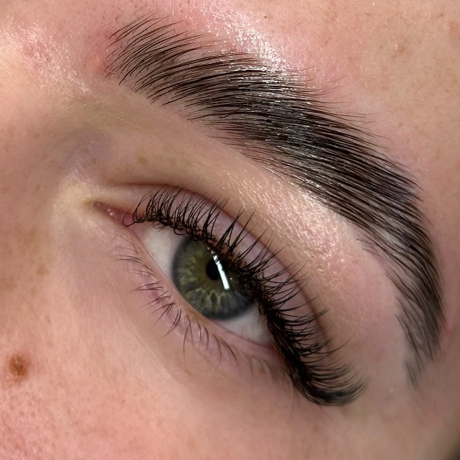 Close-up of a person's eye with long, dark eyelashes and well-groomed eyebrow.