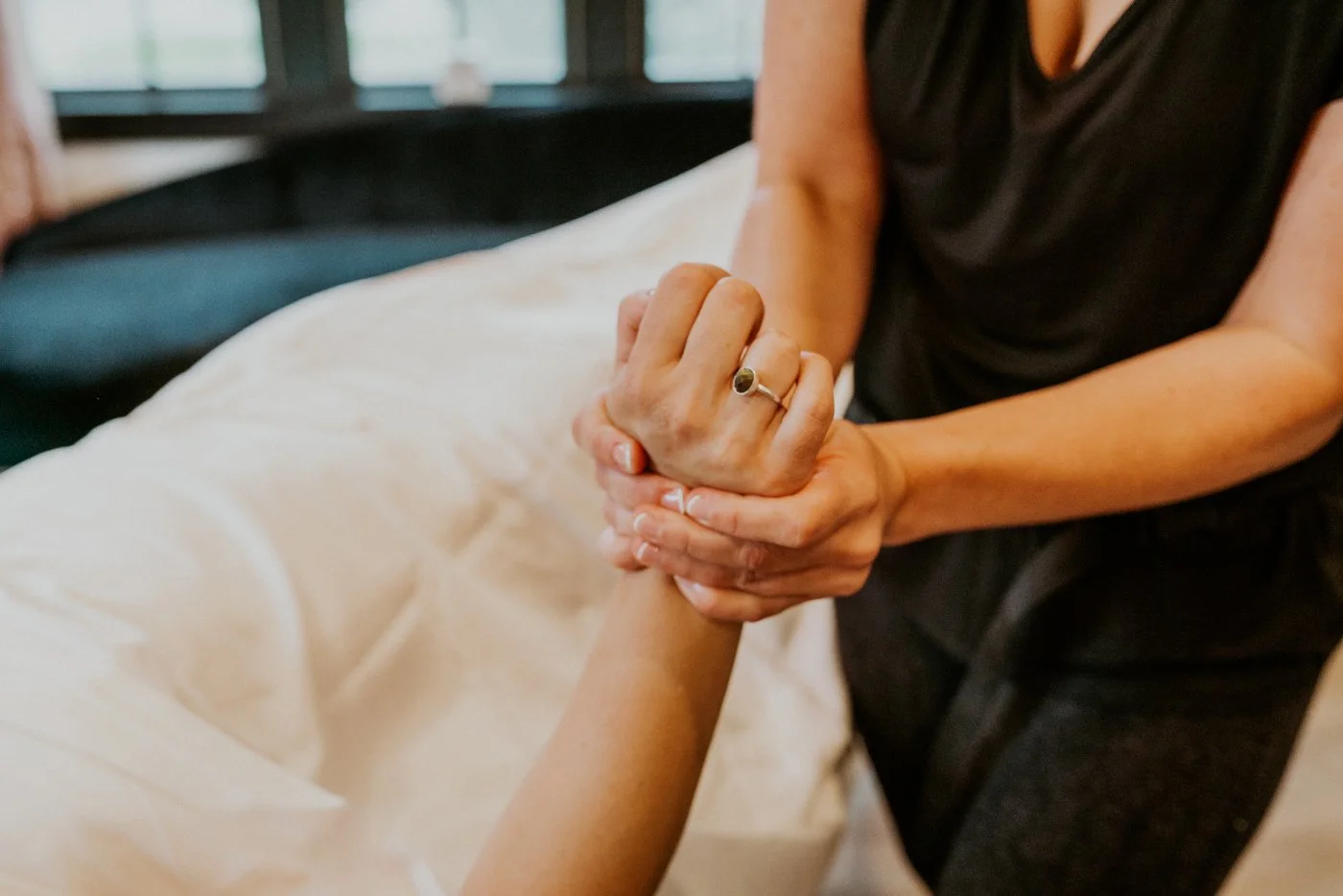 Massage therapy for pain relief and workout recovery, Jamie applies pressure to a clients hand to relax and stretch.