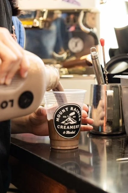 An employee pours chocolate milk into a cup