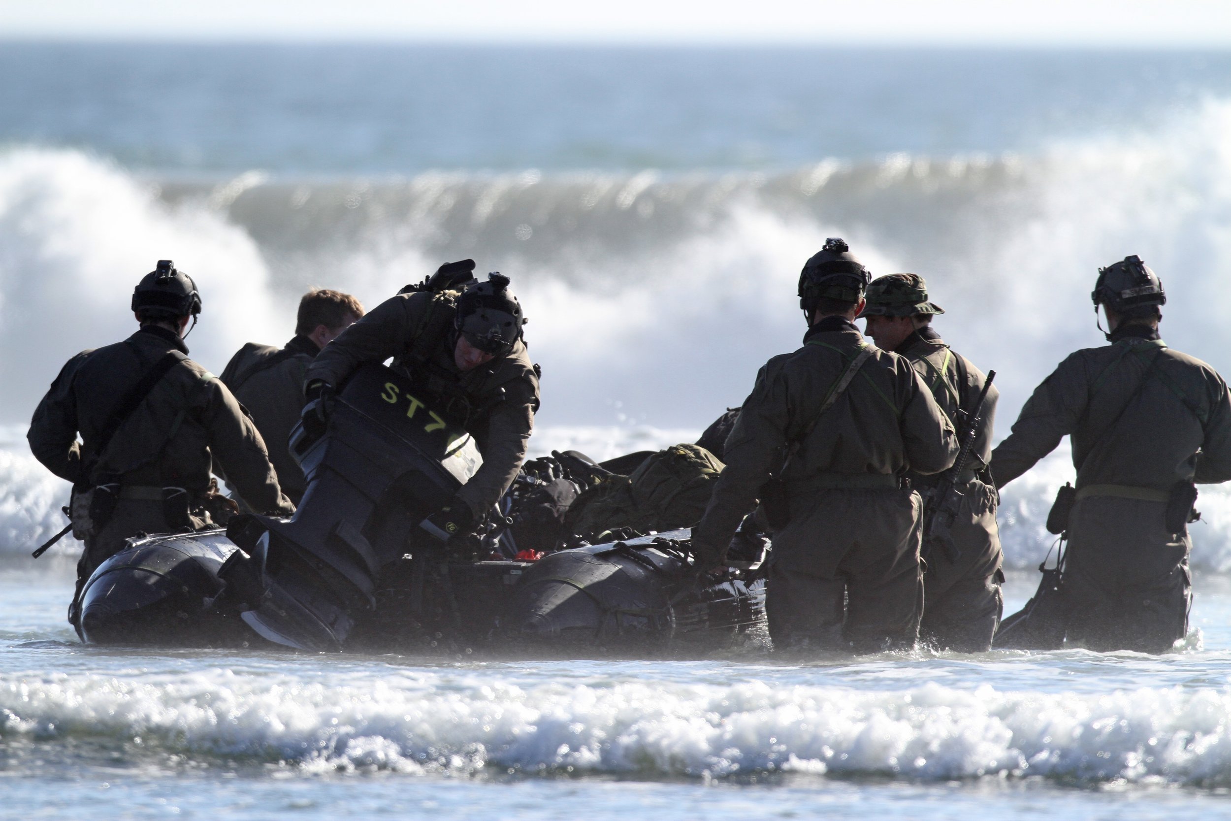 Military personnel in tactical gear riding on Inflatable Public Safety Rafts in the ocean.