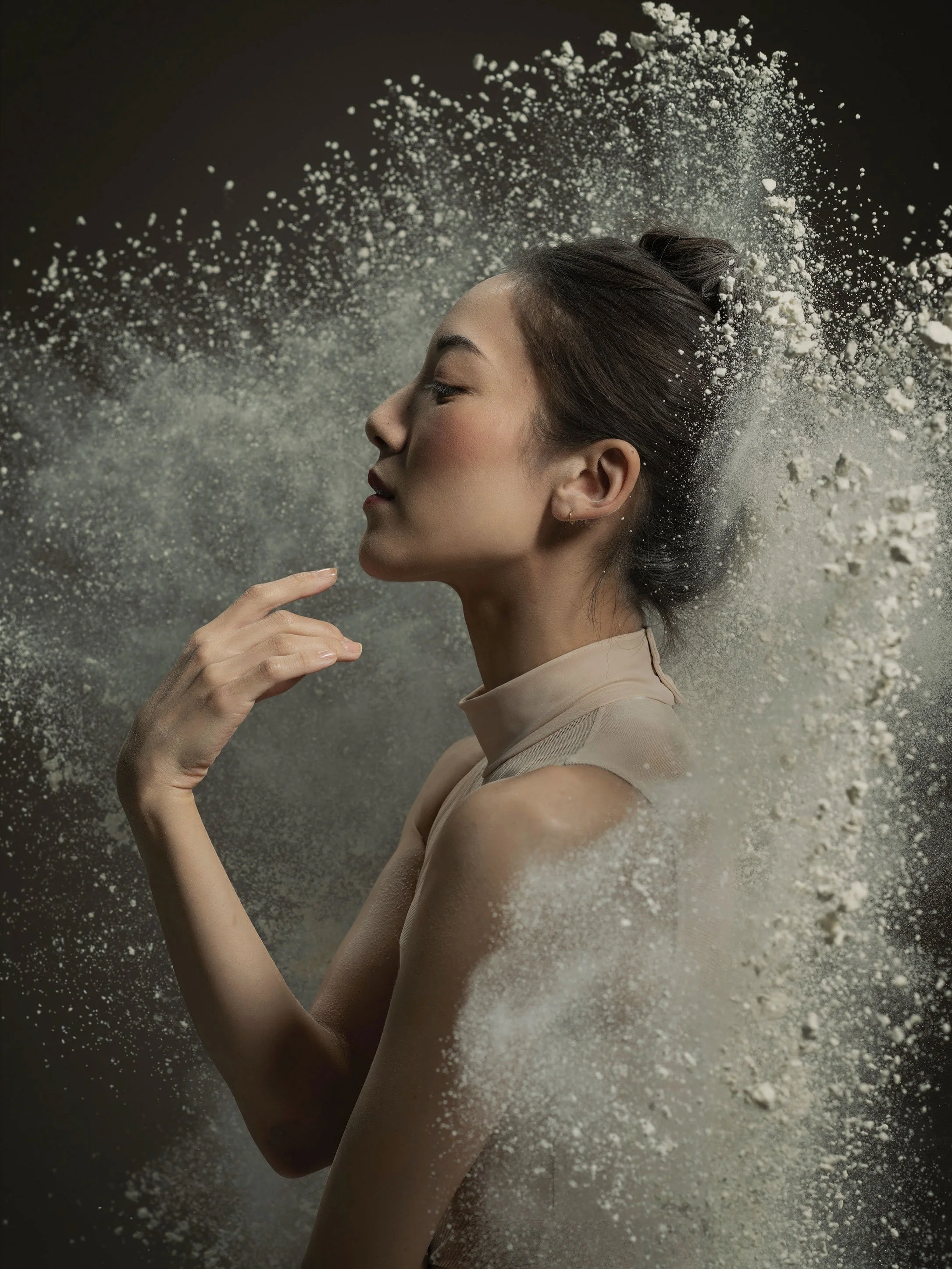 Expressive dancer portrait with airborne powder and soft directional light, capturing grace, motion and quiet intensity.