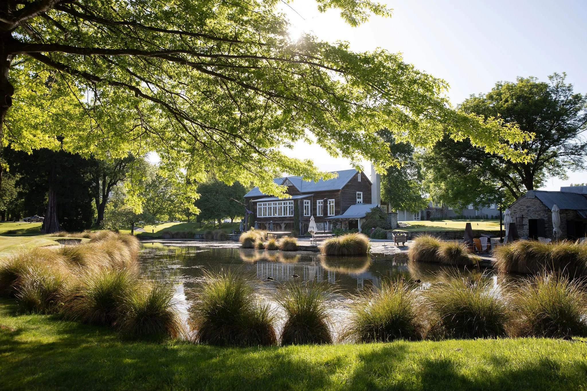 Millbrook Resort grounds with pond, trees and lodge buildings photographed in spring light.