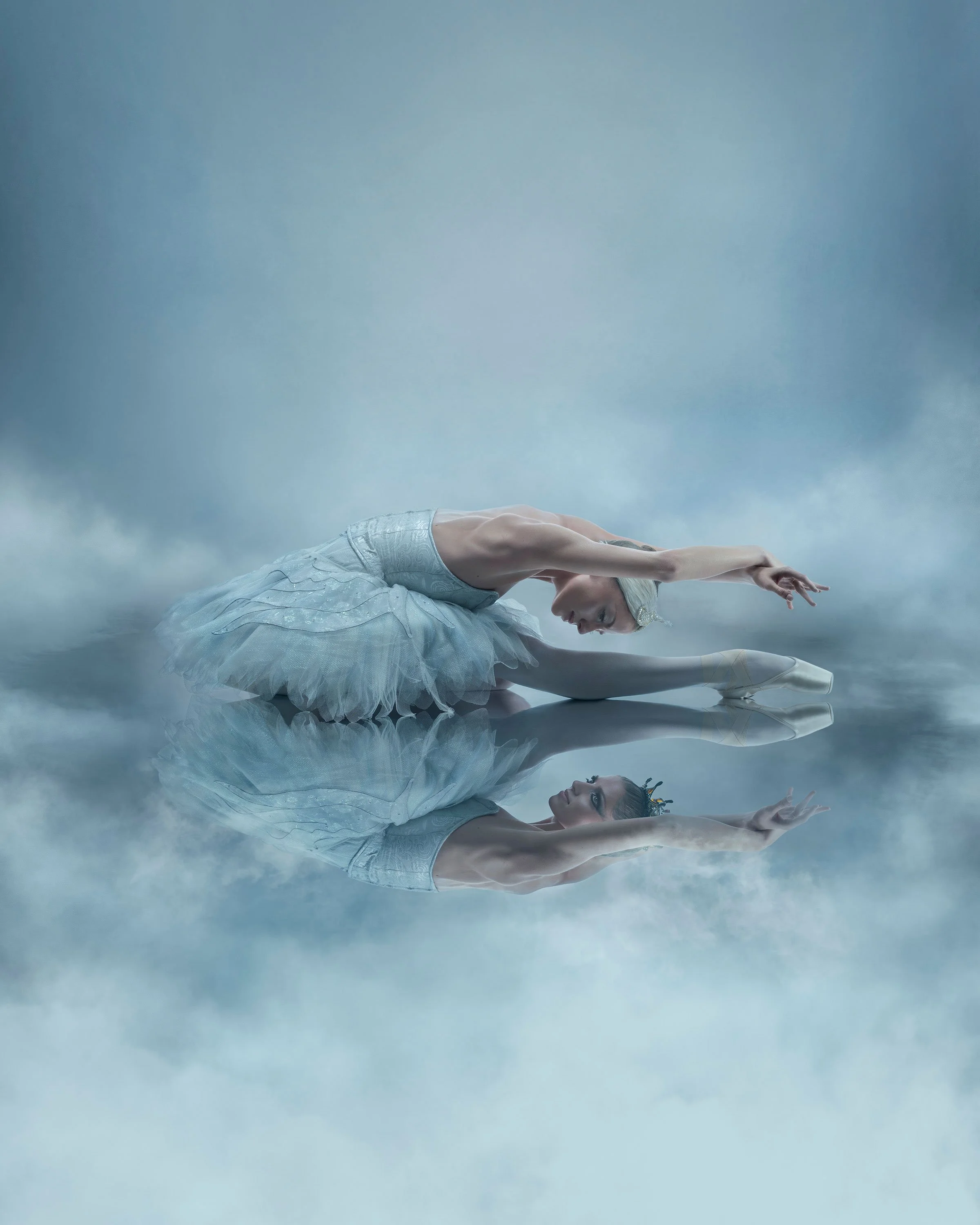 Dreamlike conceptual ballet image with reflection, mist and pale tones, creating a serene and ethereal mood.