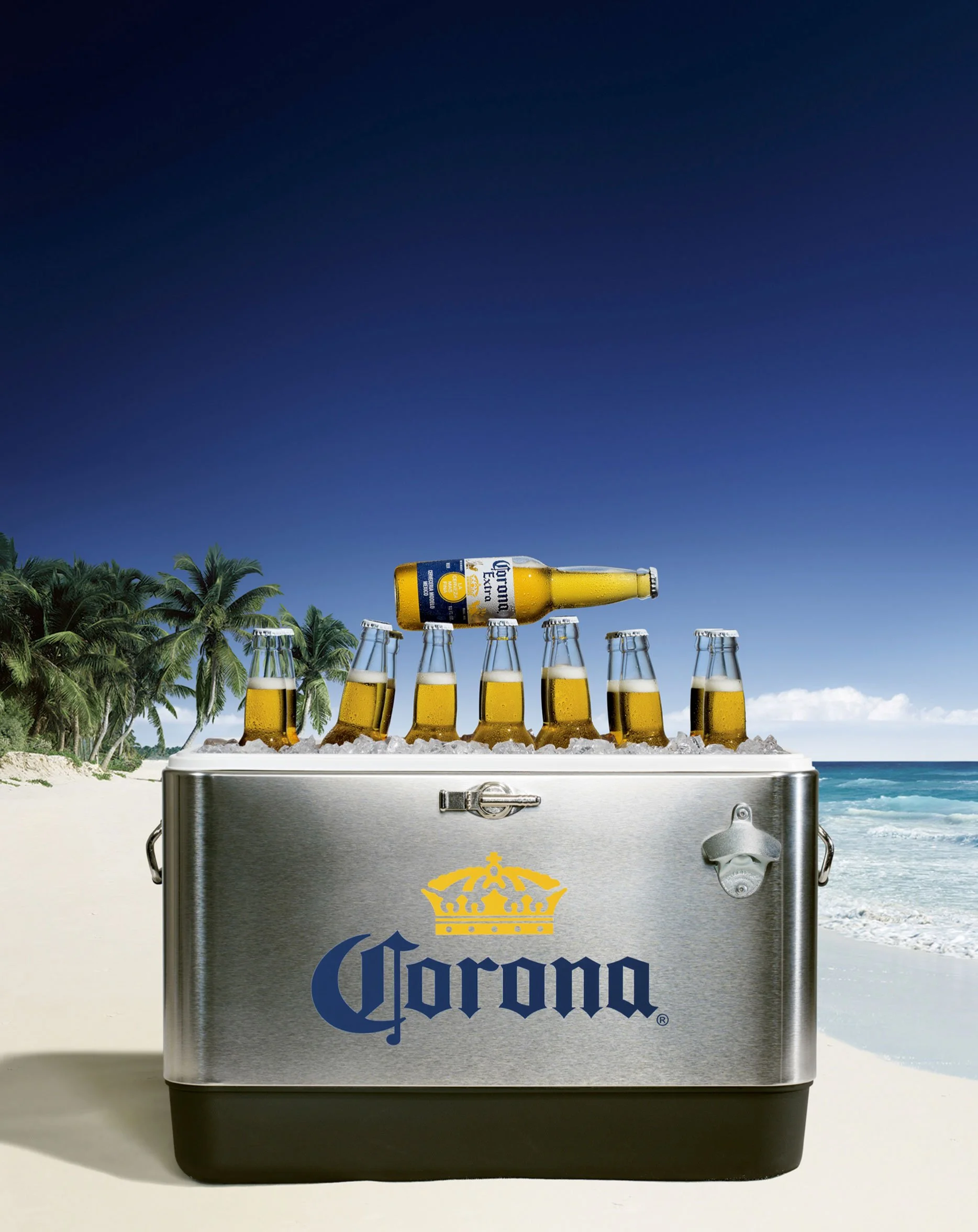 Advertising-style product image featuring a Corona cooler on a beach, combining product visibility with a bright lifestyle setting.