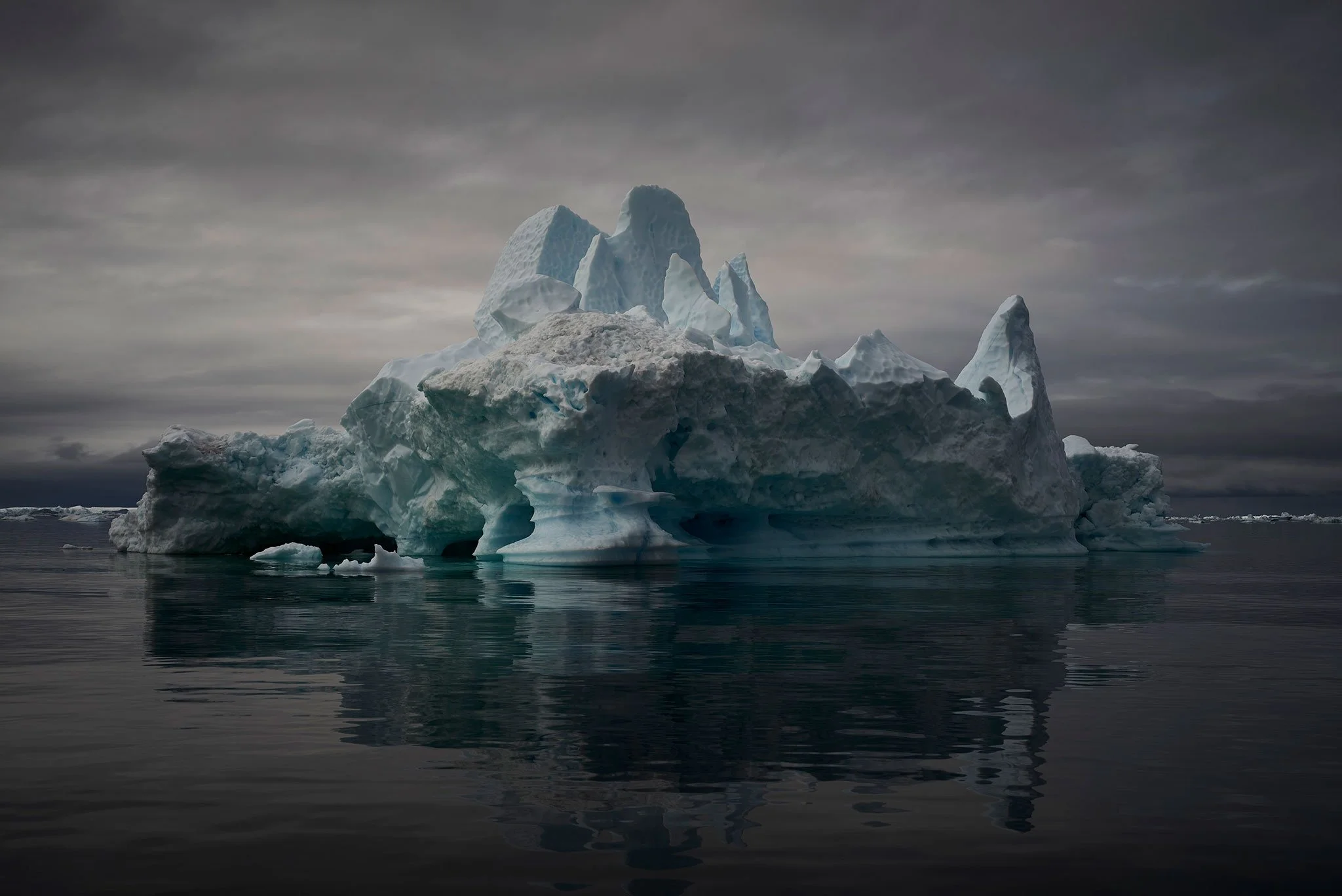 Fine art iceberg photograph with layered icy forms and muted tones, creating a cold, quiet and atmospheric polar scene.
