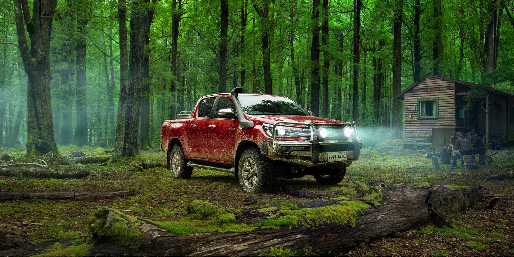 Automotive lifestyle photography by Ross Brown, featuring a Toyota Hilux in a cinematic forest setting with mist, headlights and a remote backcountry hut.