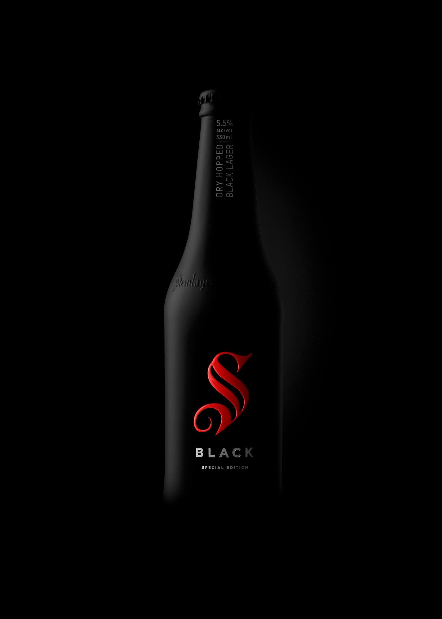 Minimal product photograph of a Steinlager Black bottle, using low-key lighting and a dark background for a premium, dramatic feel.