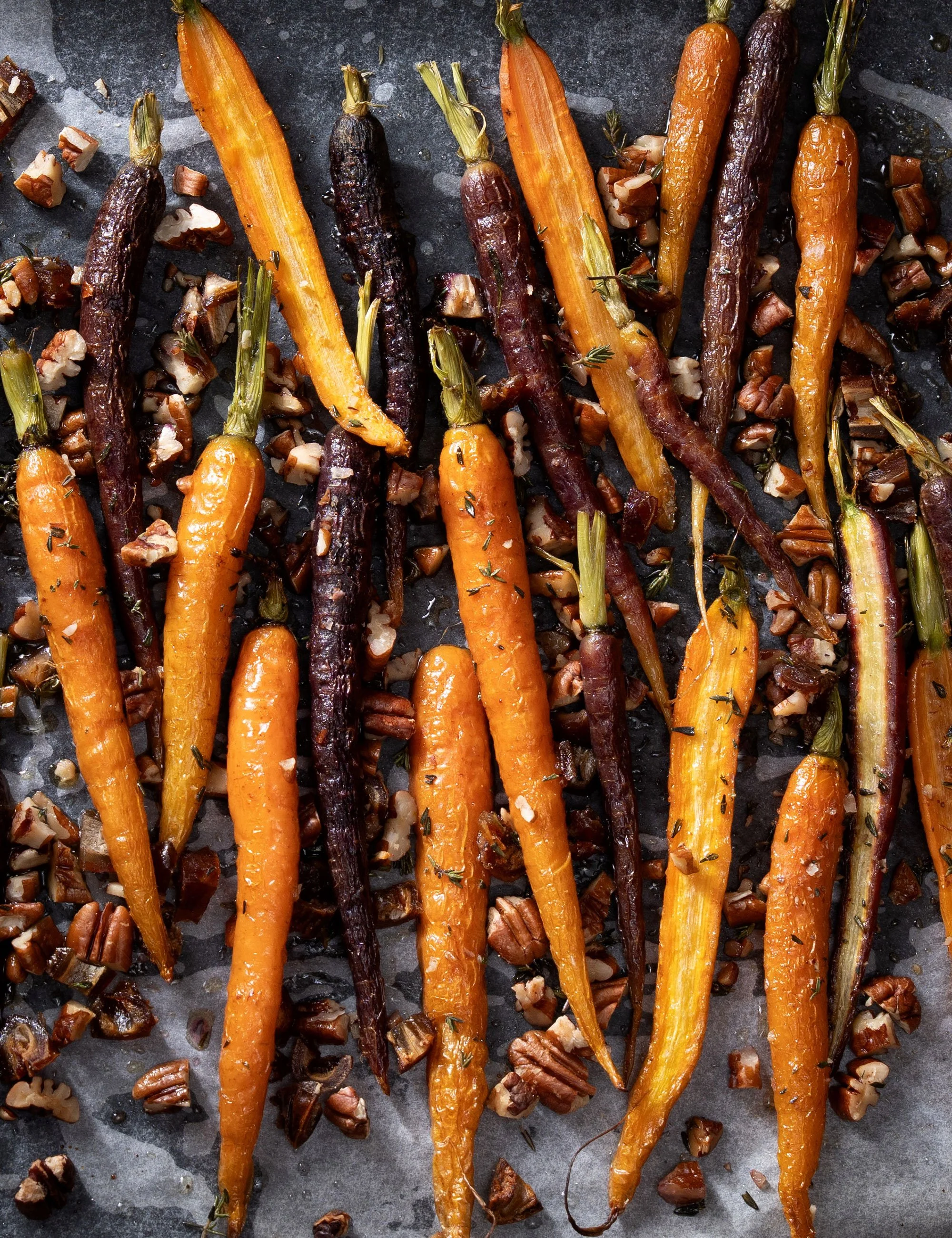 Roasted carrots with dark glaze and herbs photographed overhead.