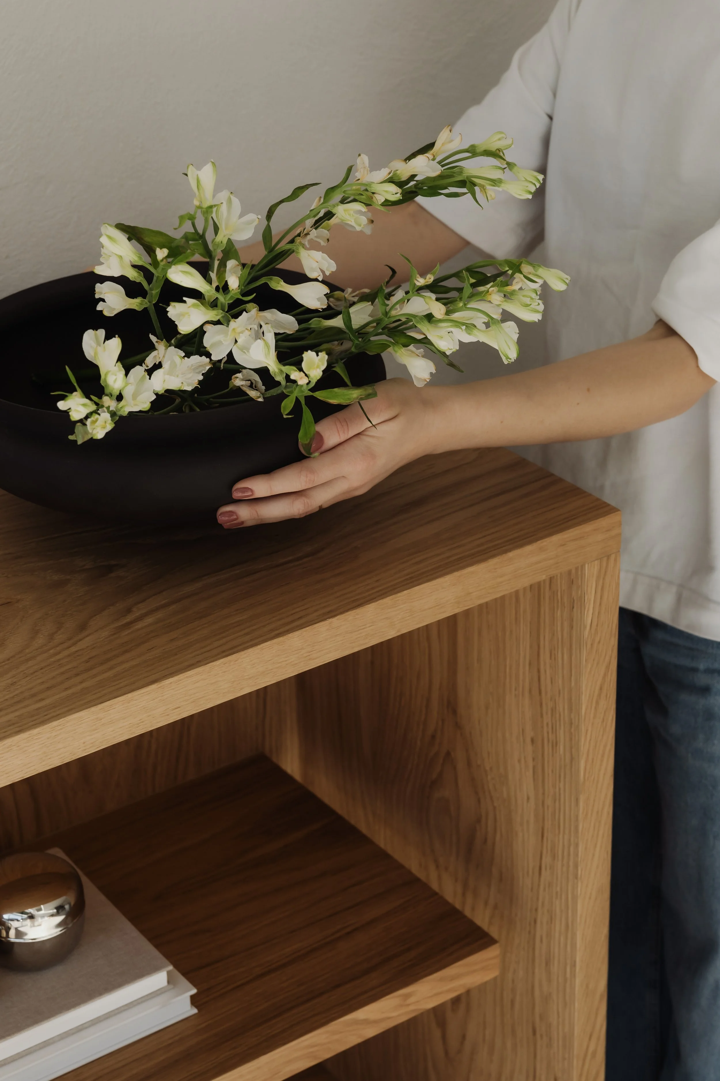 Cleaner placing flowers on polished wooden table as final touches for a perfectly clean southern Gold Coast home.