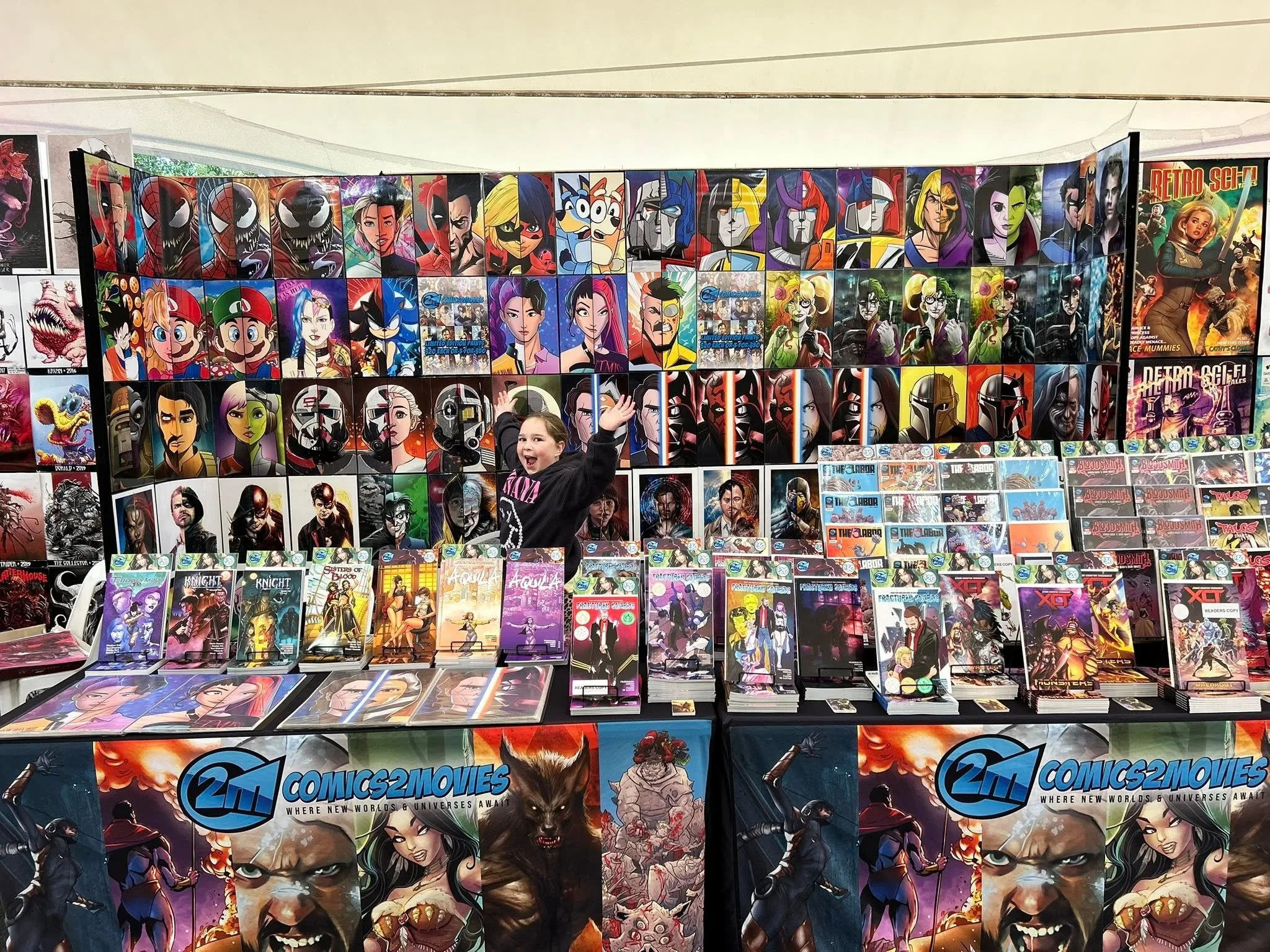 Vast display of comic book posters featuring popular characters, including Marvel, DC, and others, at a convention