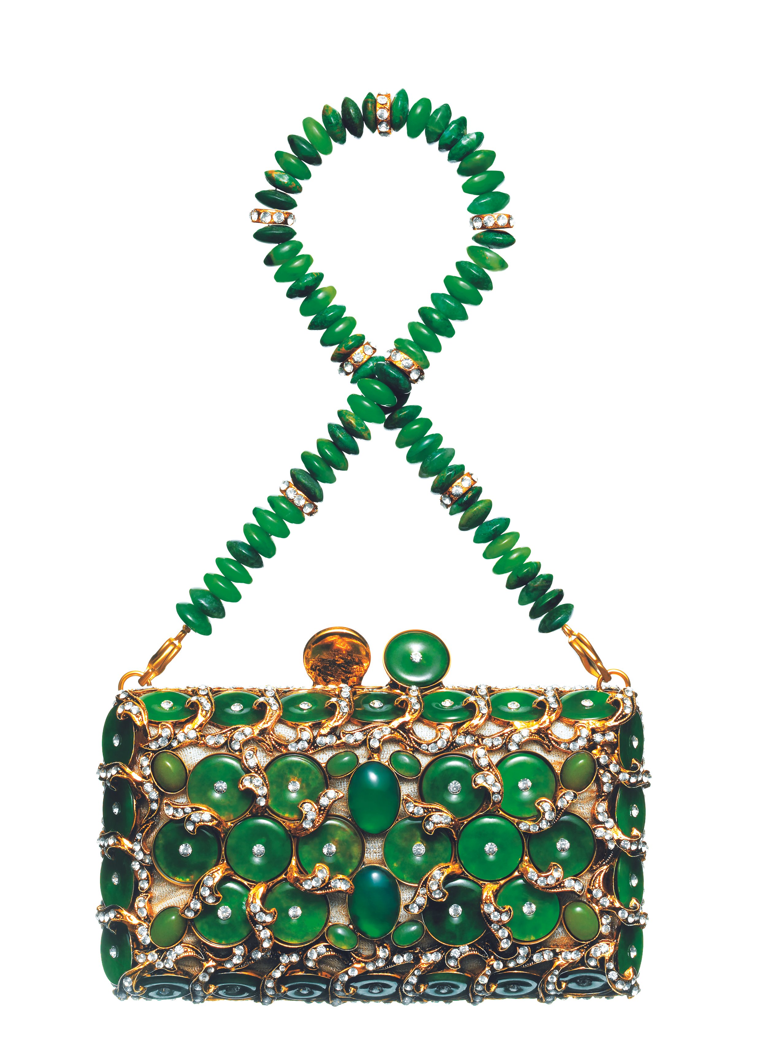 An ornate green and gold handbag with elaborate decorative stones and design, paired with matching green jewelry including a necklace and earrings.