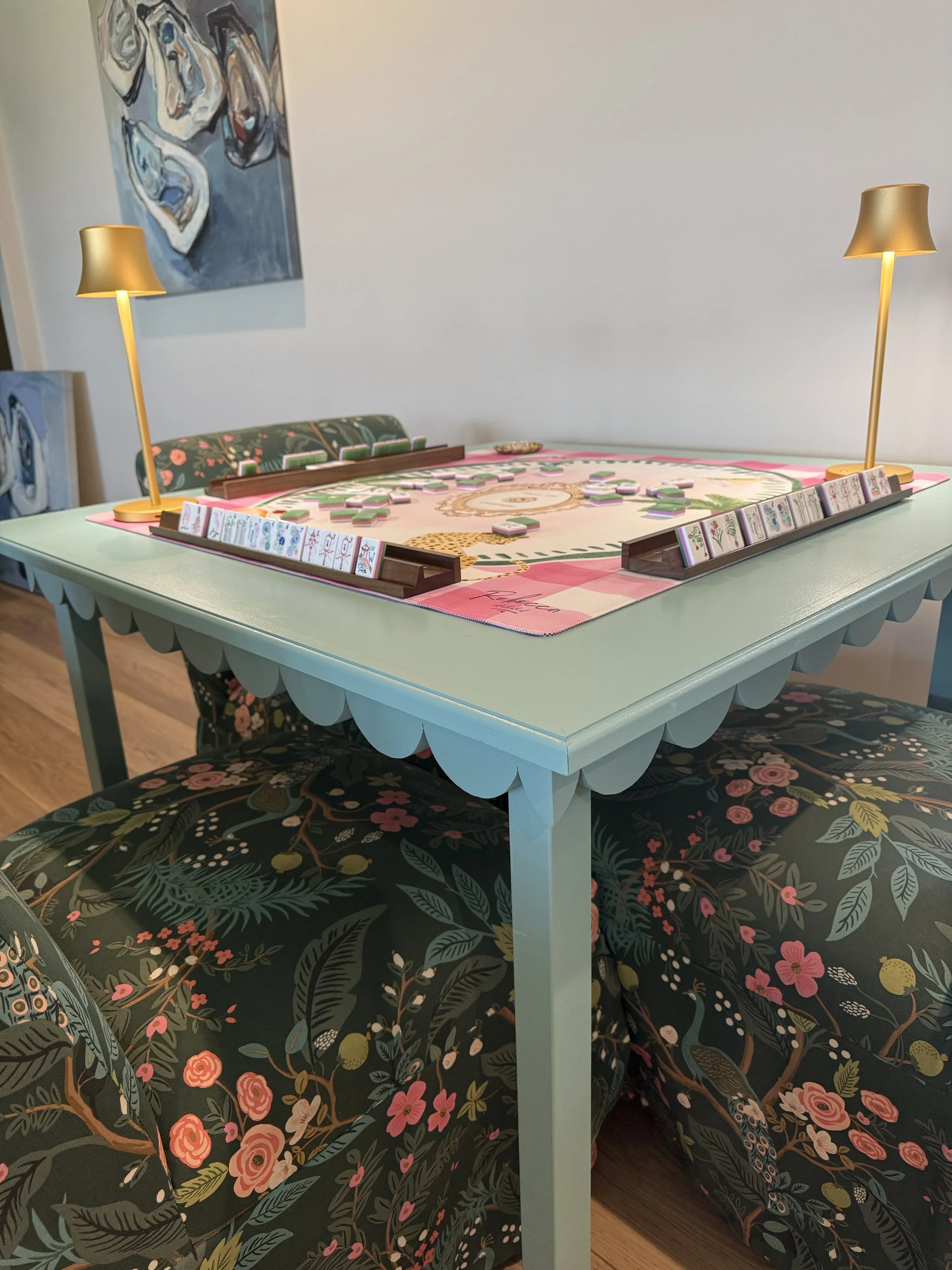 Custom painted mahjong table by The Mahj Table Co featuring scalloped edges, a pink game mat, and a beautifully styled mahjong game room setup