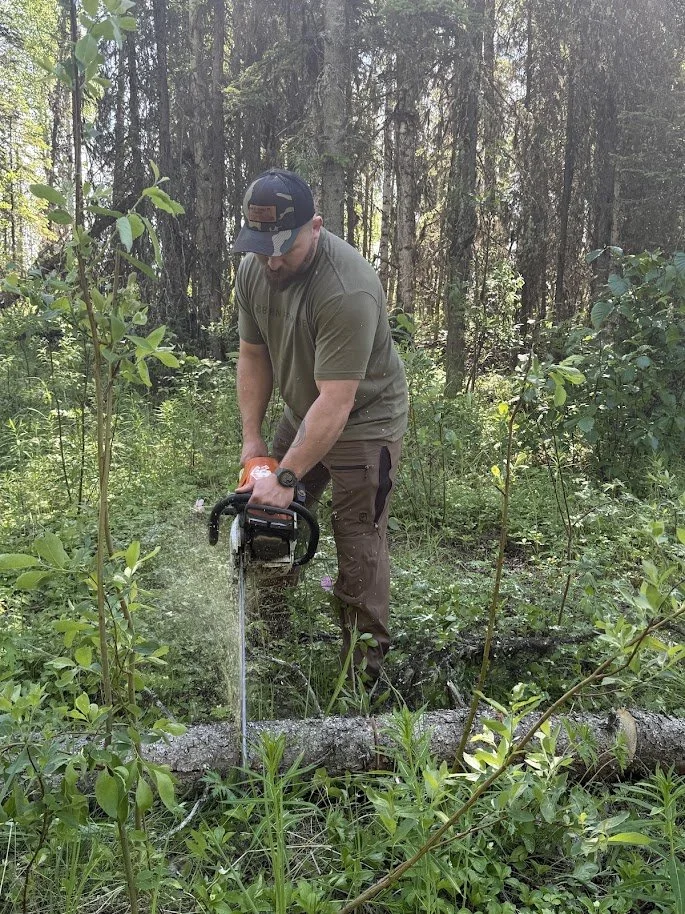 Cutting and removing a fallen tree during a property clearing project.