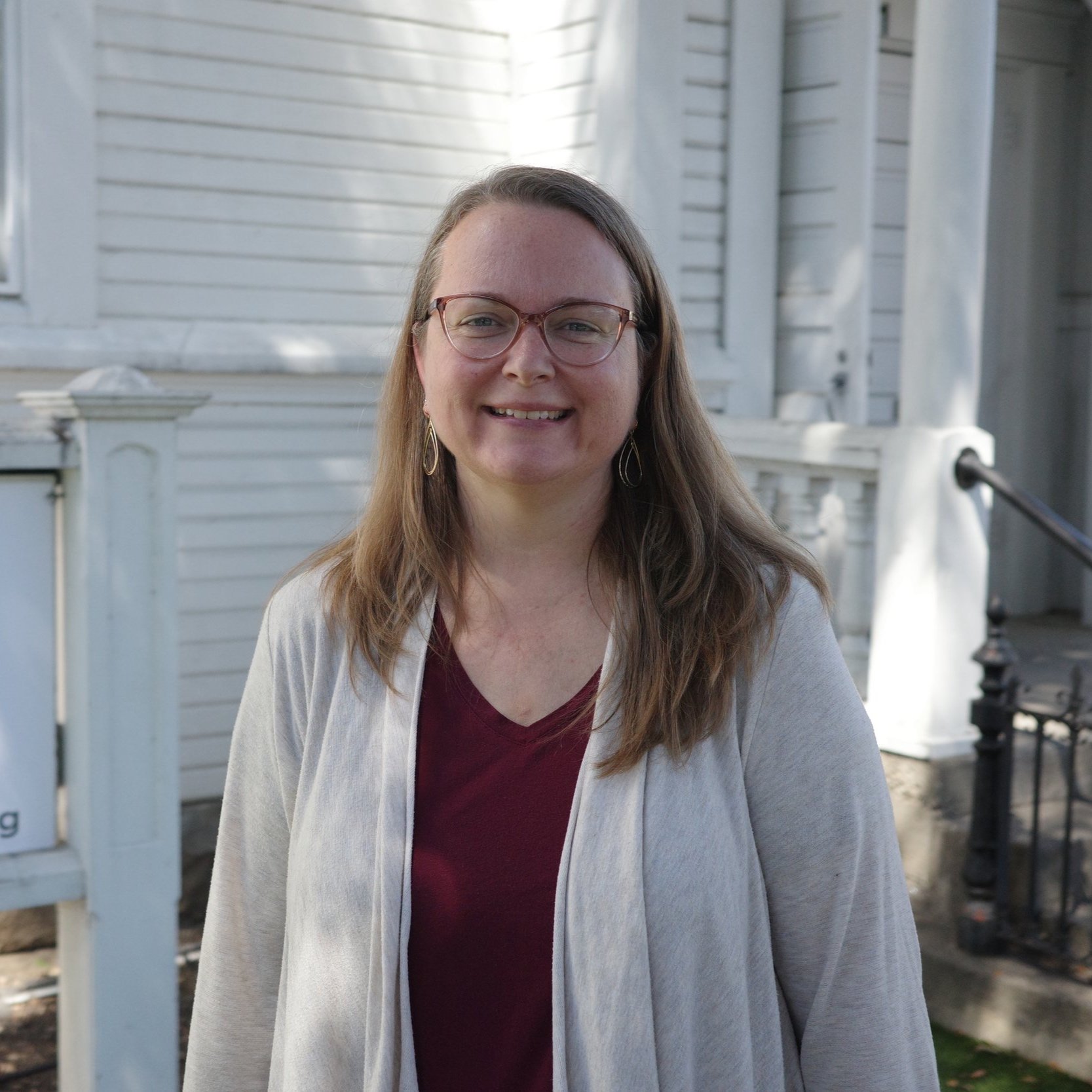Andrea Rooks, Session Advisor for Community Groups, smiling outdoors in a gray cardigan