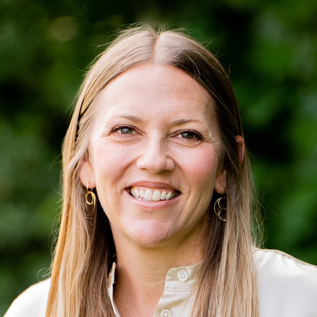 Chris Zurbach, Session Advisor, smiling outdoors with long blonde hair and gold earrings
