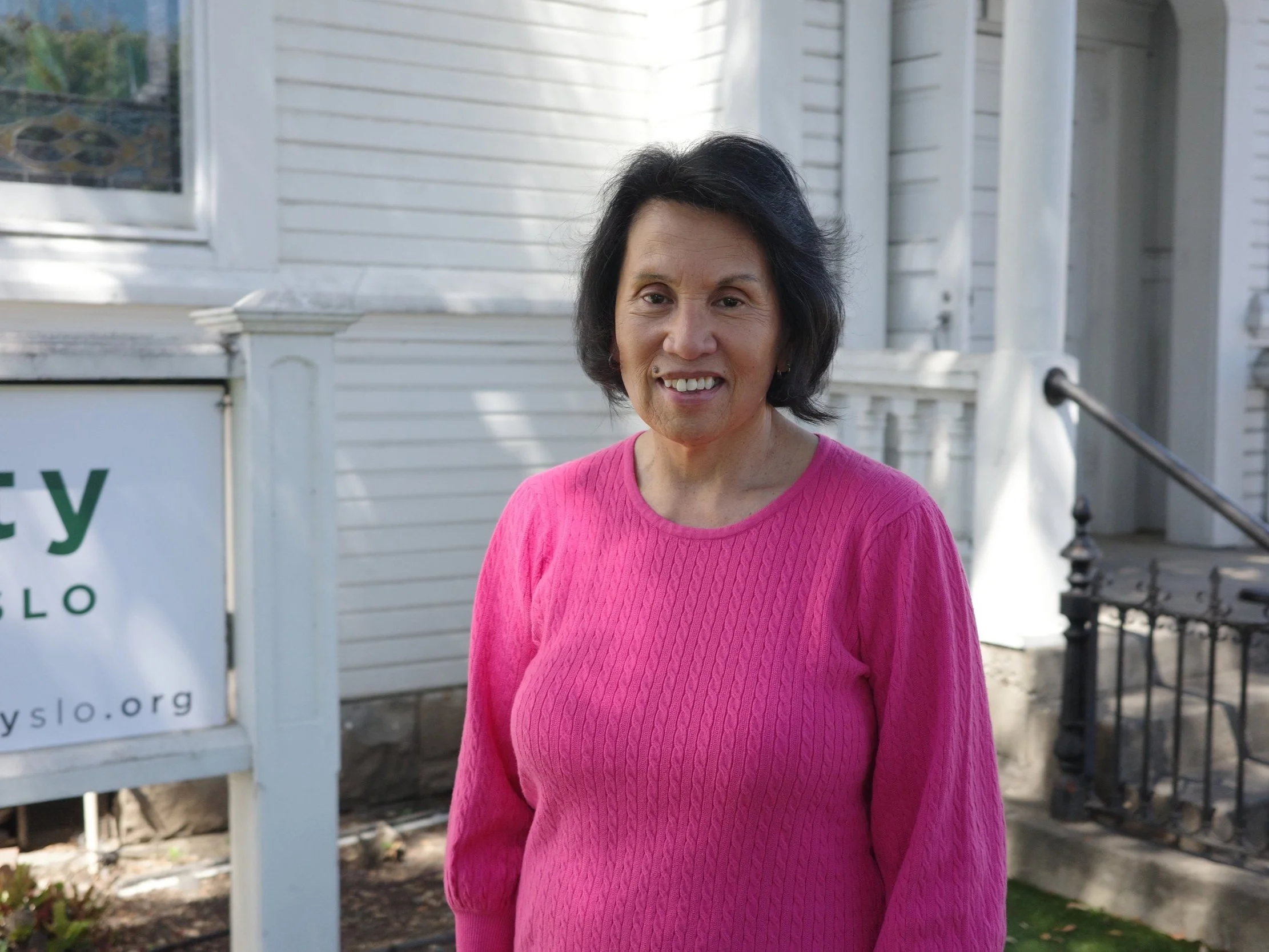 Lillian Bucton, Mercy Team, smiling outdoors in a pink sweater