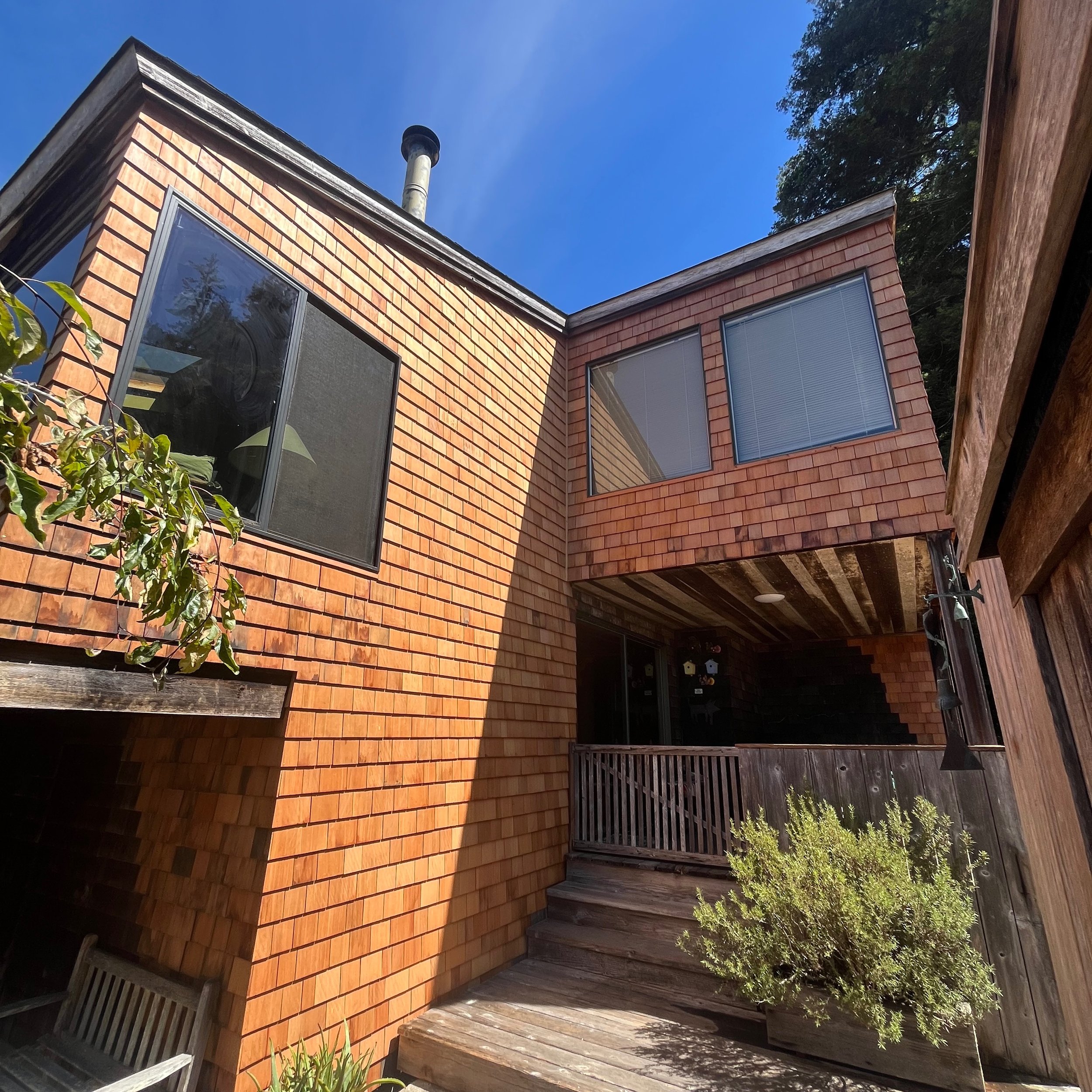 New windows and eco-salvaged old growth redwood shingles to match the home's original siding from the 70's