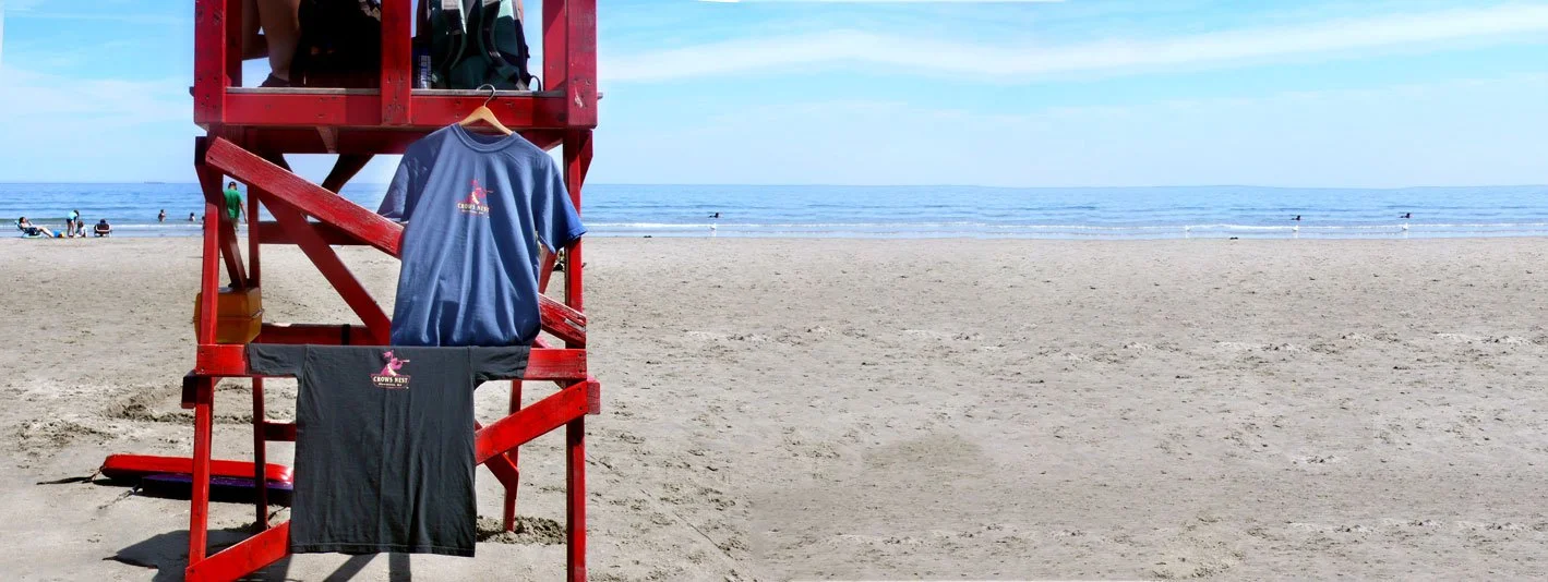 Official Crow's Nest t-shirts displayed on a red lifeguard tower at Good Harbor Beach in Gloucester MA
